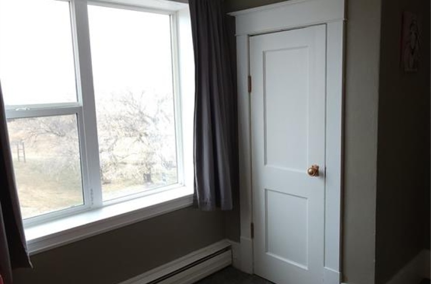 Unfurnished bedroom featuring dark carpet, a baseboard radiator, and a textured ceiling