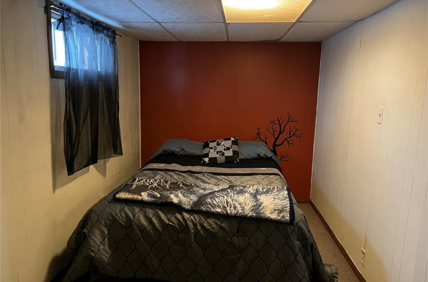 Bedroom featuring a suspended ceiling and carpet floors