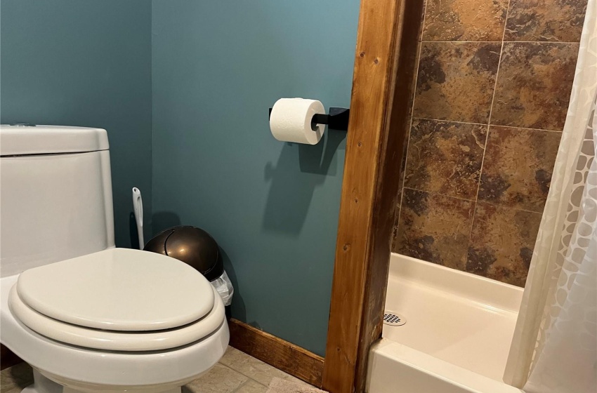 Bathroom featuring, tiled shower, tile flooring and toilet