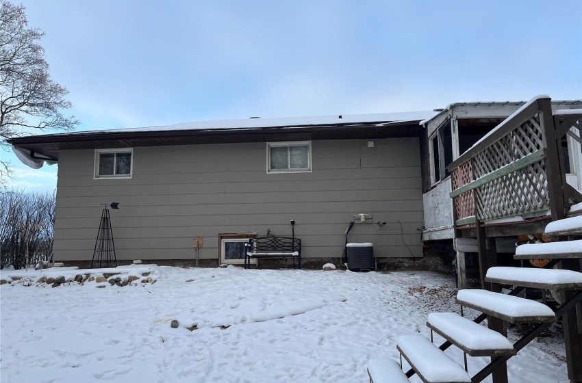 Snow covered rear of property featuring a deck and central air condition unit