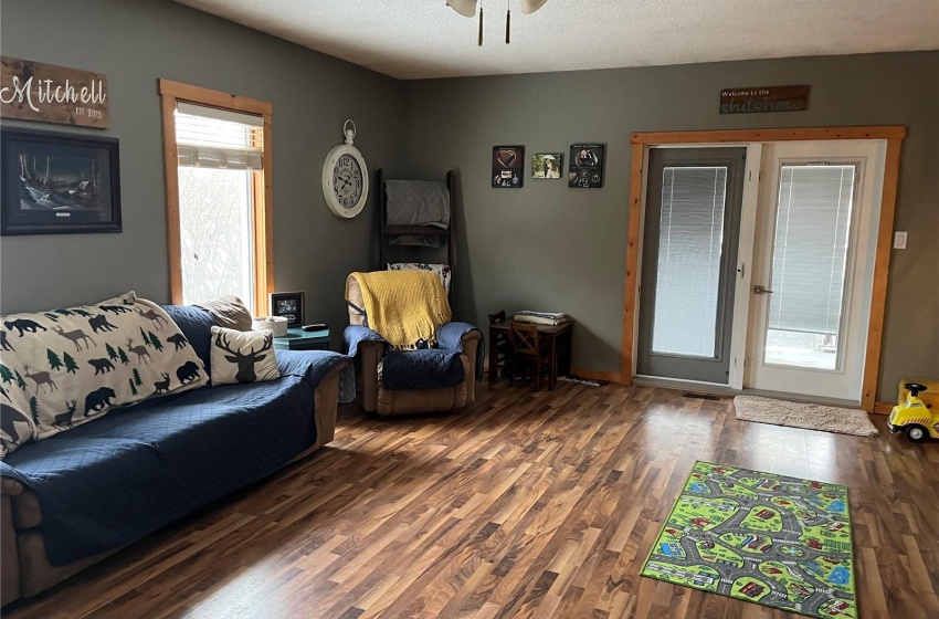 Living room featuring ceiling fan, dark hardwood / wood-style flooring, and a textured ceiling