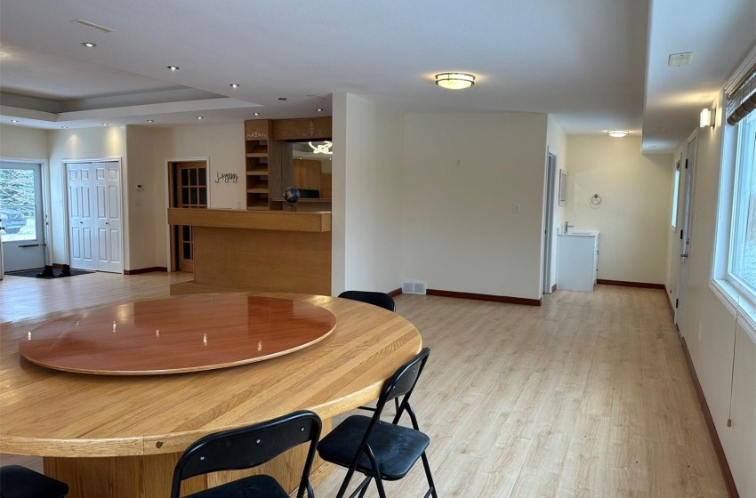 Dining area featuring light hardwood / wood-style flooring, a raised ceiling, and a healthy amount of sunlight