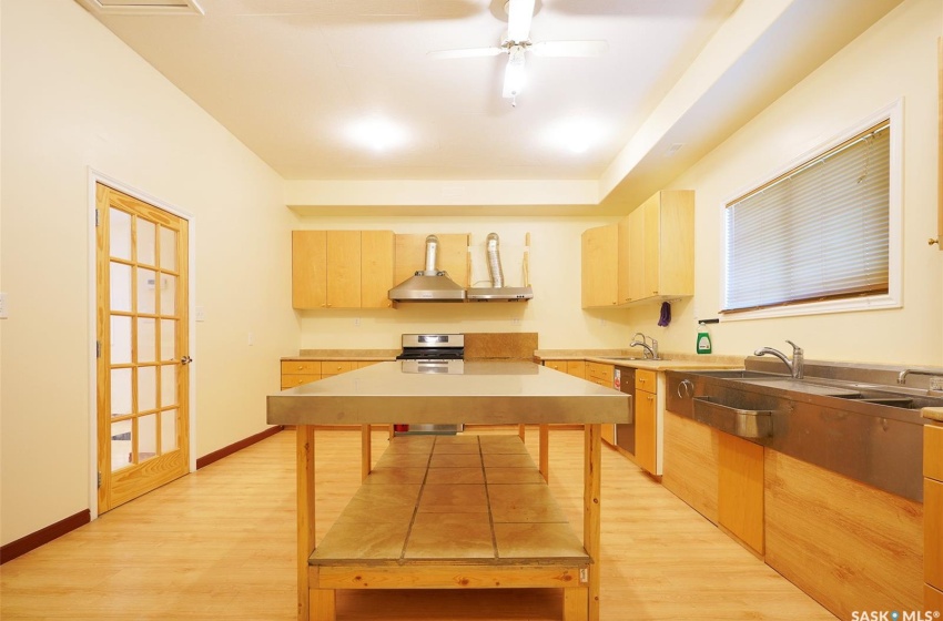 Kitchen featuring sink, ceiling fan, light brown cabinetry, and light hardwood / wood-style flooring