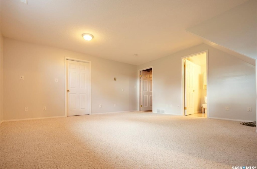 Empty room with lofted ceiling and light colored carpet