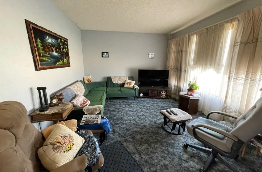 Living room with a textured ceiling and carpet flooring