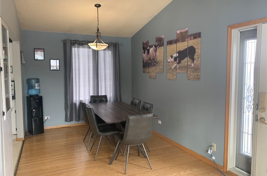 Dining space featuring vaulted ceiling and light hardwood / wood-style flooring