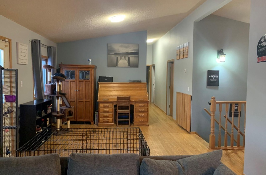 Living room featuring vaulted ceiling and light hardwood / wood-style flooring