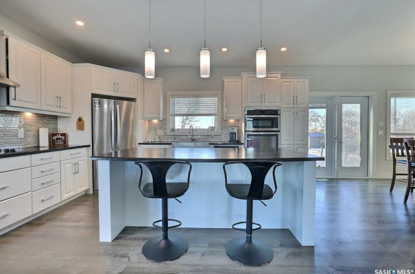 Kitchen with a center island, tasteful backsplash, hanging light fixtures, and stainless steel appliances