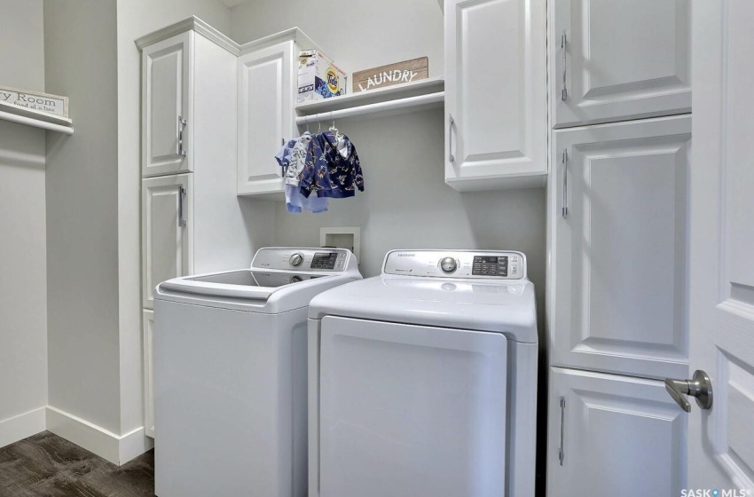 Laundry room with dark hardwood / wood-style flooring, cabinets, washer and dryer, and washer hookup