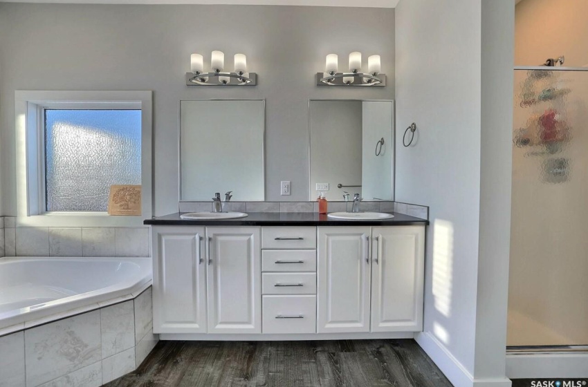 Bathroom with shower with separate bathtub, double sink, large vanity, and hardwood / wood-style flooring