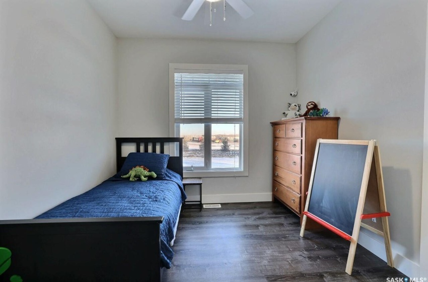 Bedroom featuring ceiling fan and dark wood-type flooring