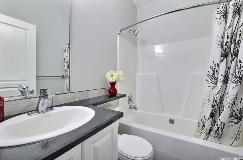 Full bathroom with toilet, shower / tub combo with curtain, and vanity