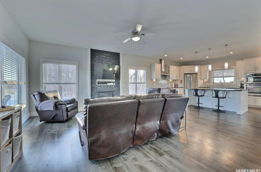 Living room with a healthy amount of sunlight, ceiling fan, a fireplace, and hardwood / wood-style floors