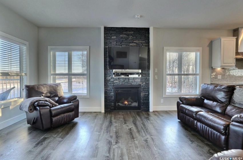 Living room with a fireplace, a healthy amount of sunlight, and hardwood / wood-style flooring