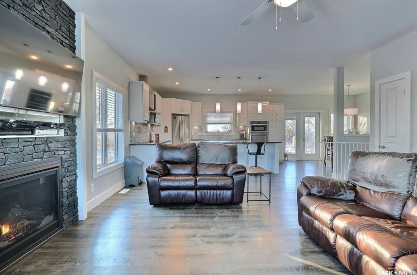 Living room featuring light hardwood / wood-style floors, ceiling fan, and a fireplace