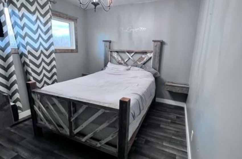 Bedroom featuring dark wood-type flooring and an inviting chandelier