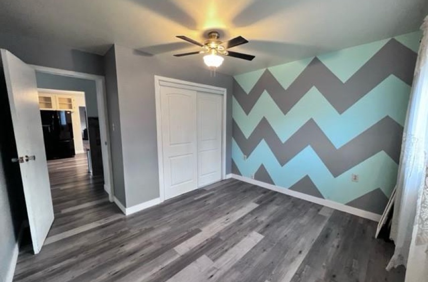 bedroom with dark hardwood / wood-style flooring, a closet, and ceiling fan