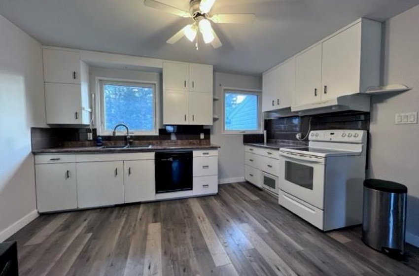 Kitchen with white cabinets, plenty of natural light, white electric range oven, and dishwasher