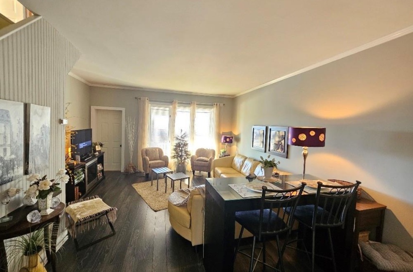 Living room featuring laminate wood-style flooring and crown molding