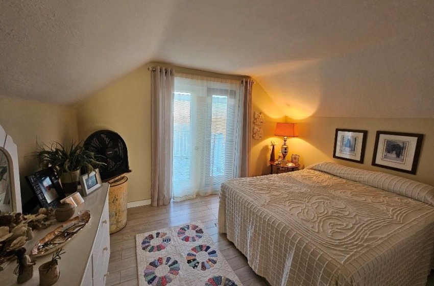 Bedroom featuring lofted ceiling, a textured ceiling.