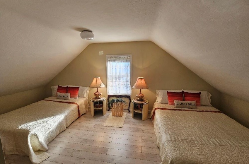 Bedroom with vaulted ceiling, a textured ceiling.