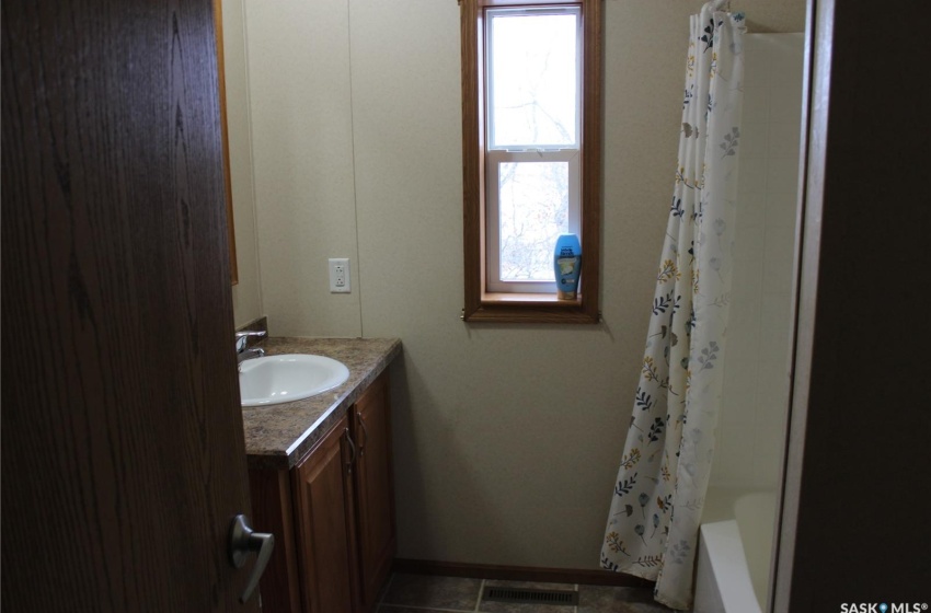 Bathroom featuring shower / bath combination with curtain, tile flooring, and vanity