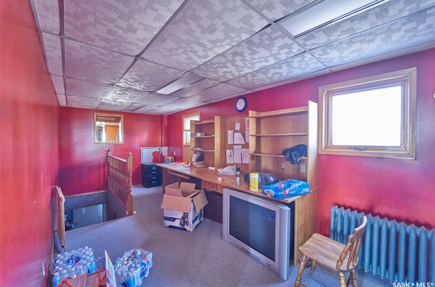 Carpeted office space featuring radiator