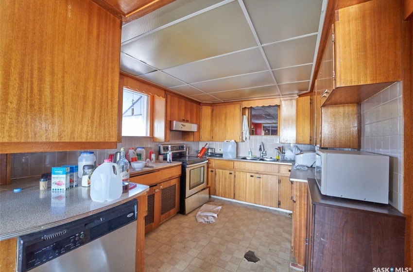 Kitchen with sink, light tile flooring, tasteful backsplash, and appliances with stainless steel finishes