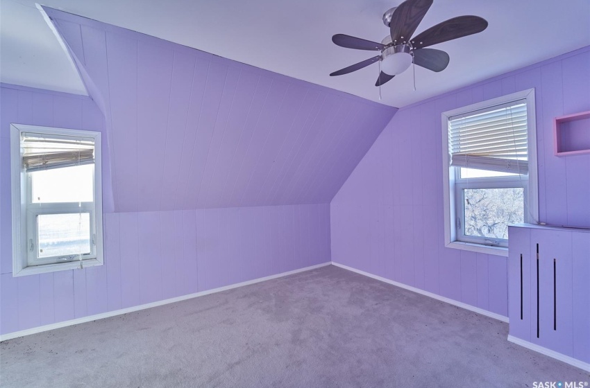 Additional living space with lofted ceiling, light colored carpet, and ceiling fan