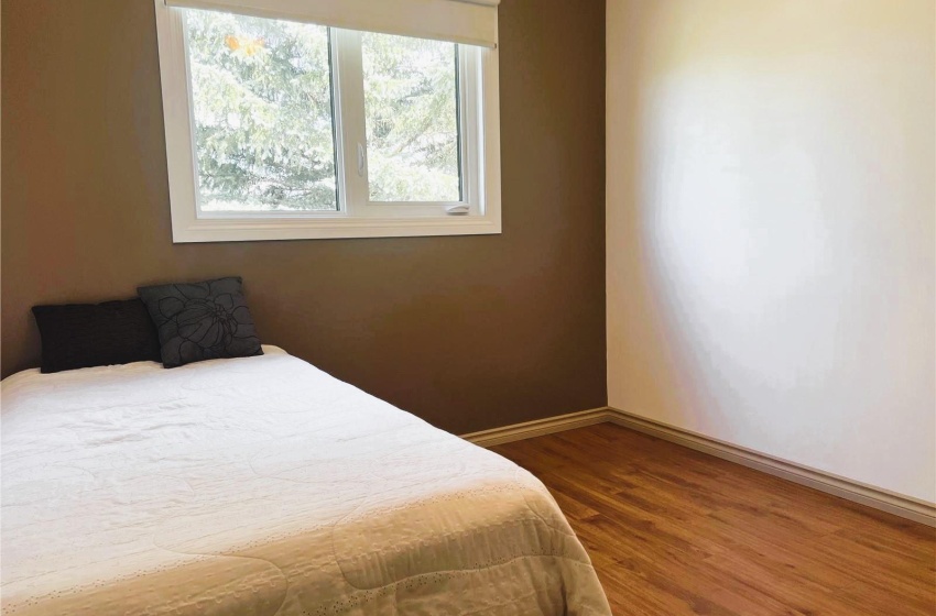 Bedroom with dark hardwood / wood-style flooring