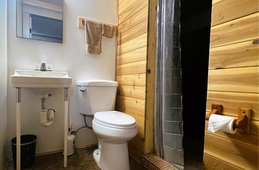 Bathroom featuring toilet and wooden walls