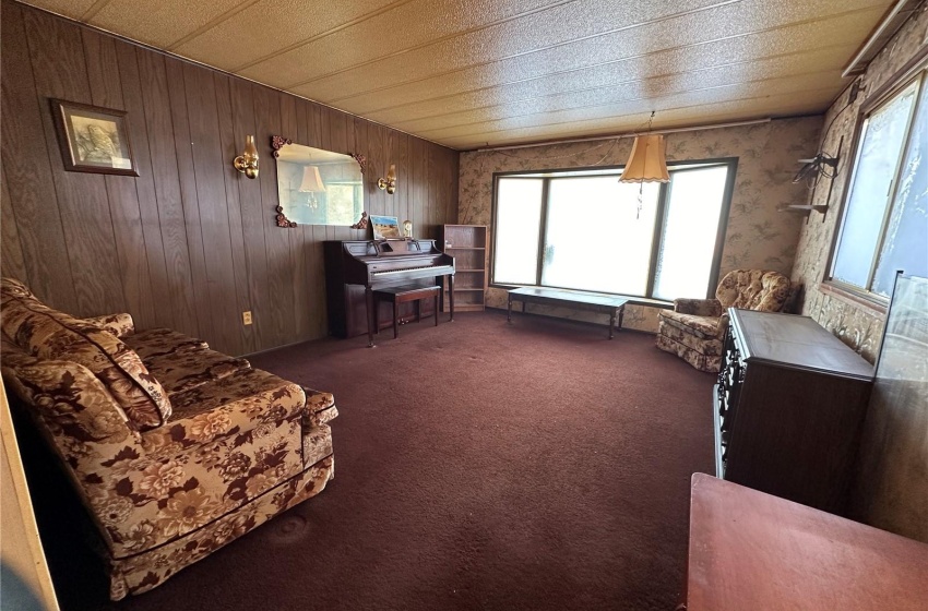 Living room featuring dark carpet and wood walls