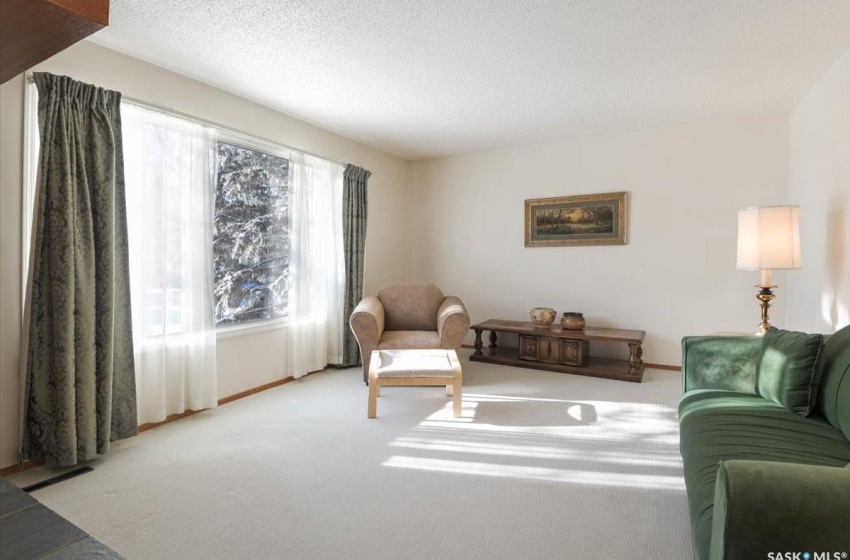 Carpeted living room with a textured ceiling