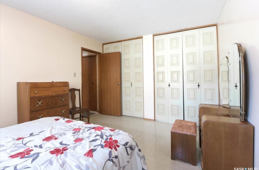 Bedroom with a textured ceiling and two closets