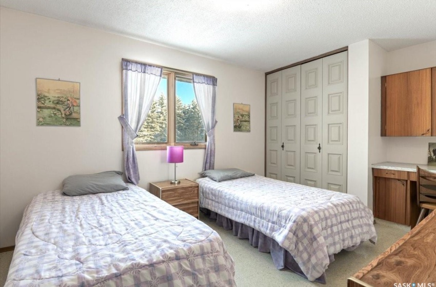 Carpeted bedroom with a closet and a textured ceiling