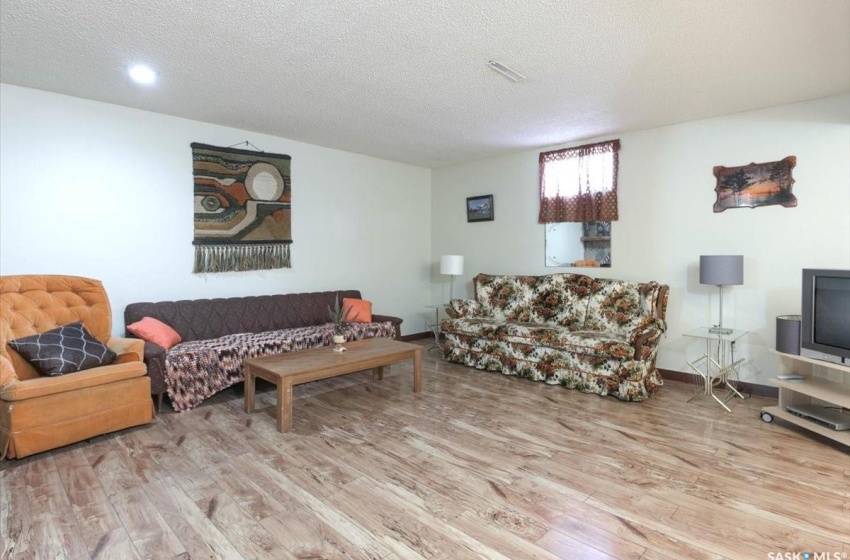 Living room featuring light wood-type flooring and a textured ceiling