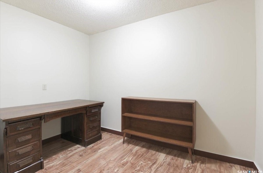 Home office featuring light wood-type flooring and a textured ceiling