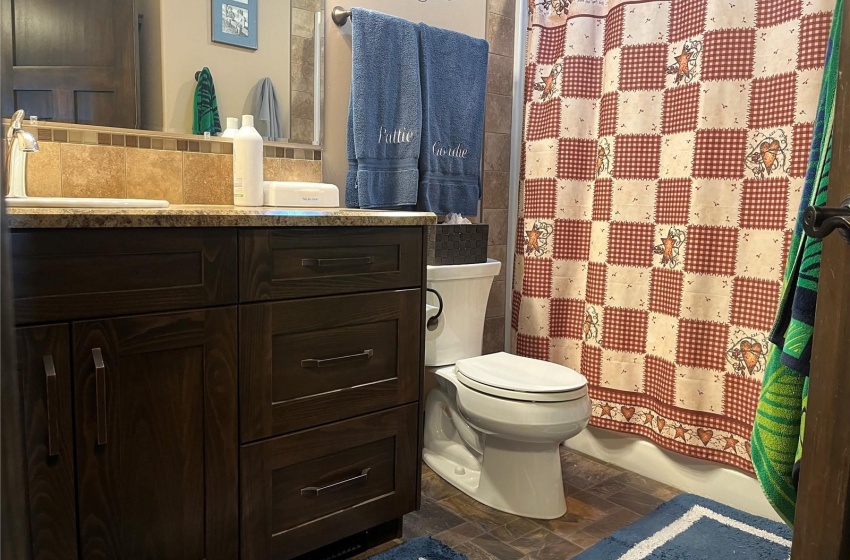 Bathroom with large vanity, Full shower/tub, and toilet