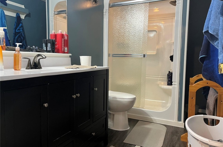 Bathroom featuring vanity, toilet, an enclosed shower, and hardwood / wood-style flooring