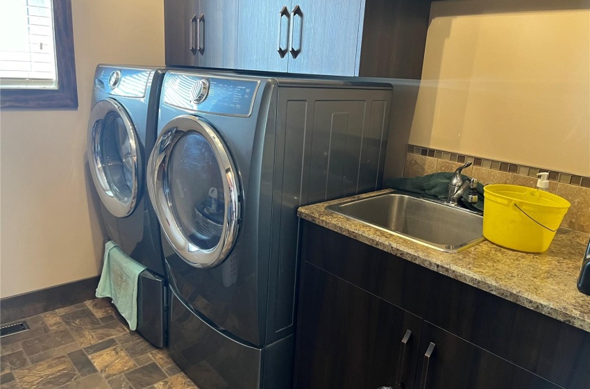 Clothes washing area featuring cabinets, sink