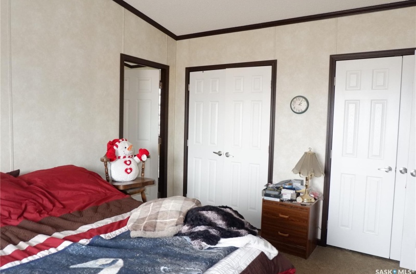 Carpeted bedroom with ornamental molding