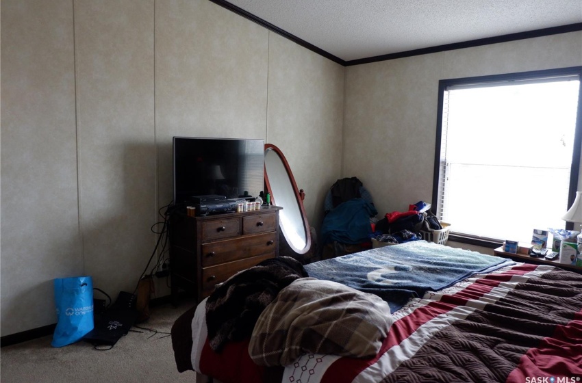 Bedroom with crown molding, a textured ceiling, and carpet flooring