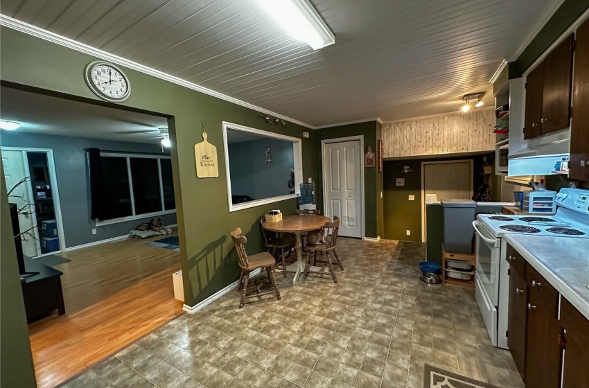 Kitchen with light floors, crown molding, dark brown cabinetry, and white electric stove