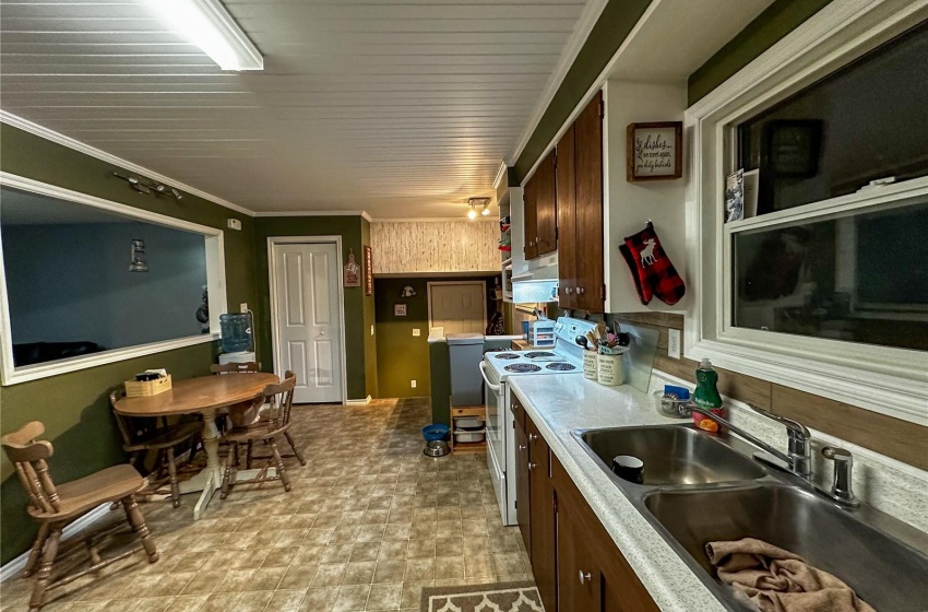 Kitchen featuring light floors, crown molding, sink, and electric stove