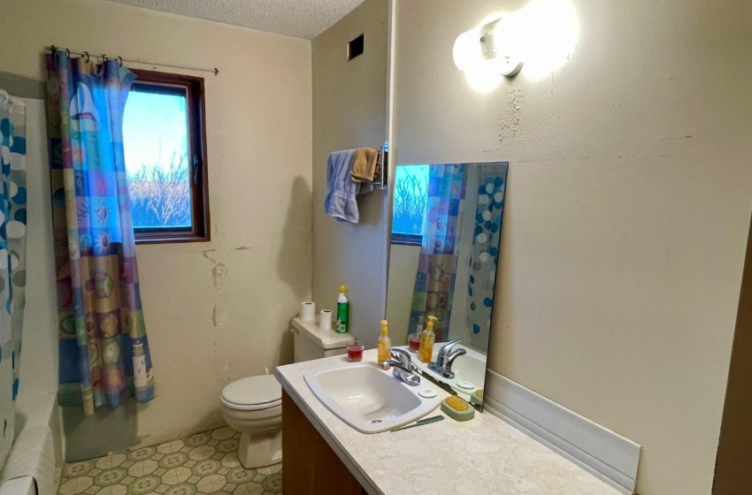 Full bathroom featuring shower / bath combo with shower curtain, toilet, a textured ceiling, oversized vanity, and linoleum floors