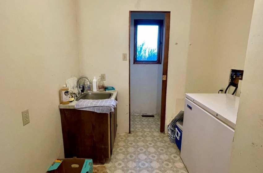 Laundry room with sink and light linoleum floors