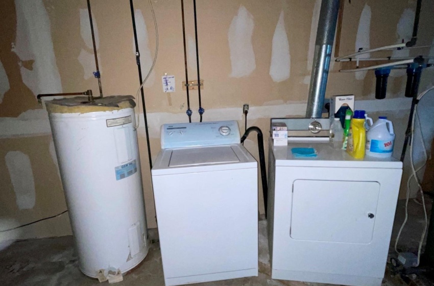 Laundry area featuring electric water heater and washing machine and dryer