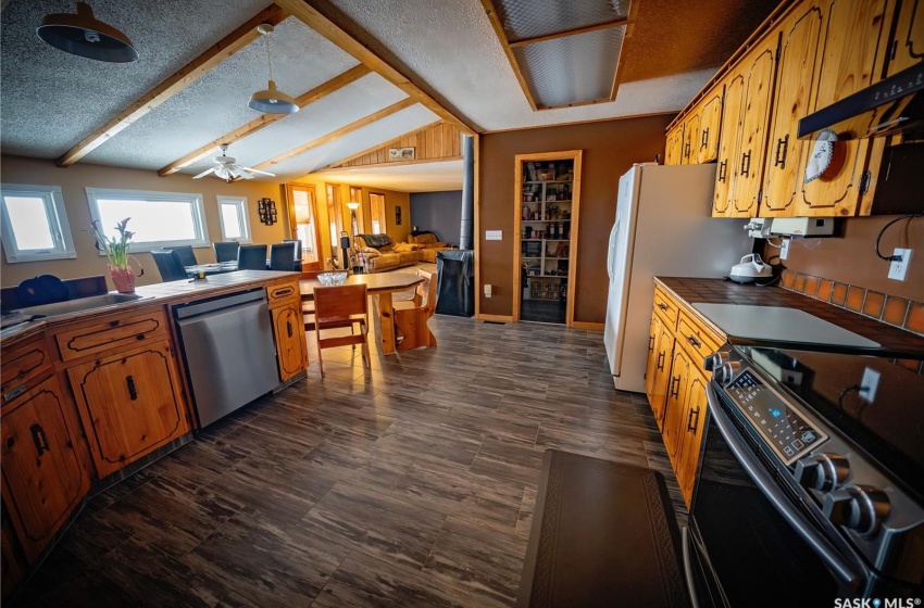 Kitchen with black electric range, a textured ceiling, stainless steel dishwasher, dark hardwood / wood-style floors, and ceiling fan