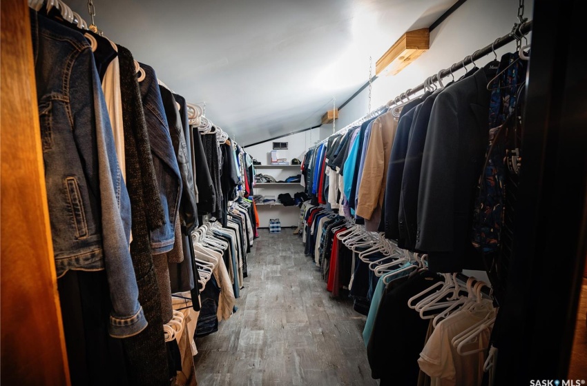 Walk in closet featuring dark hardwood / wood-style flooring and lofted ceiling