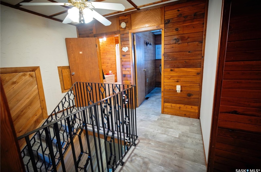 Hallway featuring light hardwood / wood-style floors and wood walls